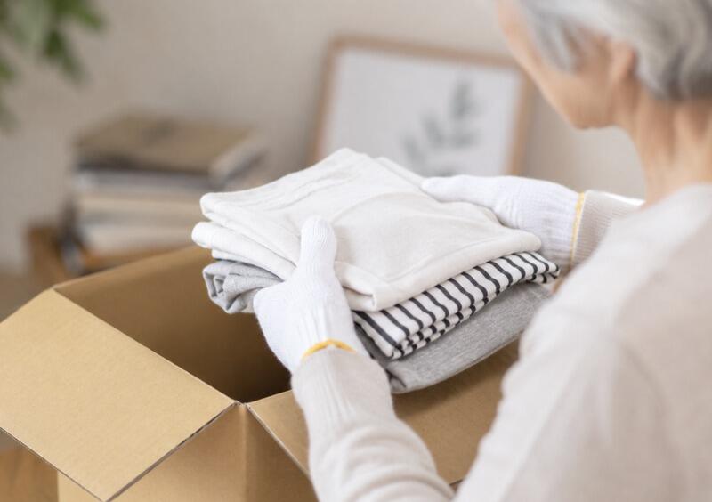 elderly_person_packing_clothes_box.jpg