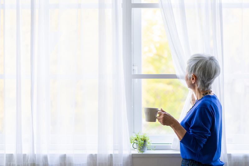 elderly_woman_drinking_by_window.png