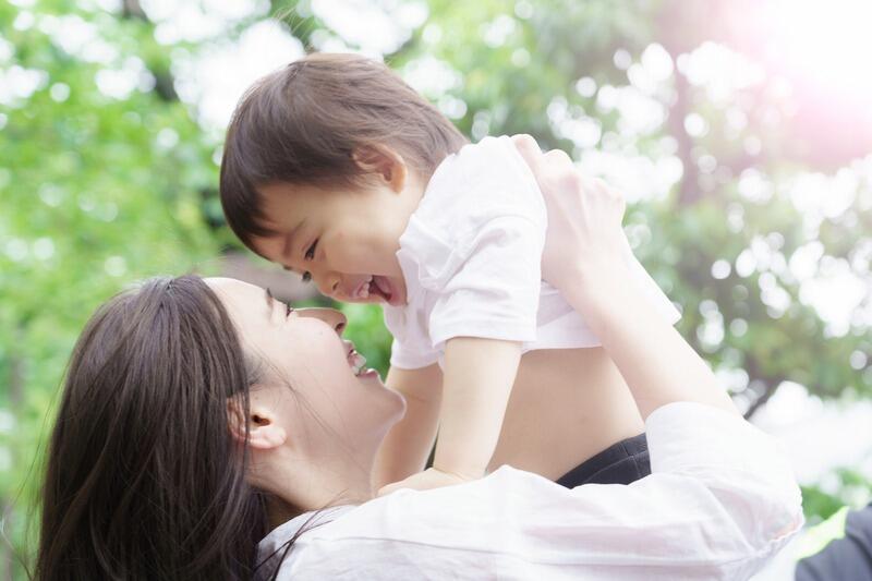 mother_lifting_baby_outdoors_joy.jpg